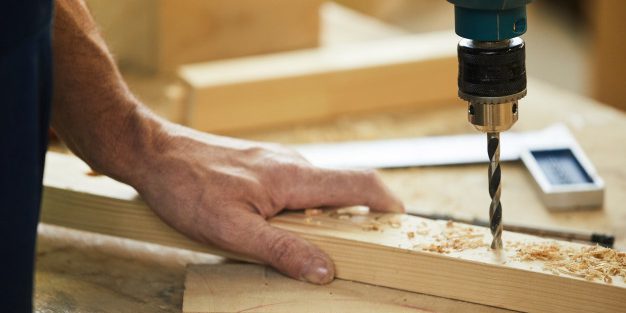 carpenter-drilling-wood-closeup_236854-15177