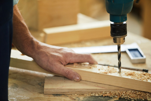 carpenter-drilling-wood-closeup_236854-15177